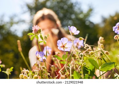 Blooming Flowers In Spring And Child With Hay Fever Blowing Nose In Background