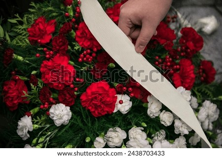 Blooming red and white carnations in a bouquet with blank white ecru ribbon placed for celebration in indonesion polish maltan colors poland malta indonesia
