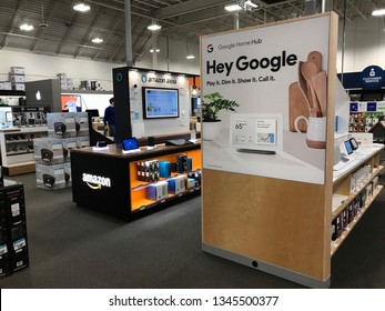 Bloomington, MN/USA. January 4, 2019. The Interior Of A Best Buy Showing A Display Of Google Home Products Next To A Display Of Amazon’s Alexa.