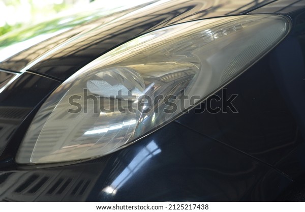 BLORA, INDONESIA\
– February 16, 2022: parts of a Honda Yaris sedan, wheels, front\
tires, left headlights, side body, mirrors, front part between car\
lights. Selective focus