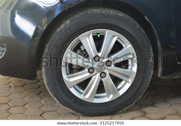 BLORA, INDONESIA\
– February 16, 2022: parts of a Honda Yaris sedan, wheels, front\
tires, left headlights, side body, mirrors, front part between car\
lights. Selective focus