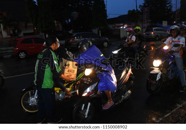 Blora-May 25, 2018: driver Online\
ojeg Grab distributes food at a traffic light intersection to\
worship in the holy month of Ramadhan, Central Java,\
Indonesia