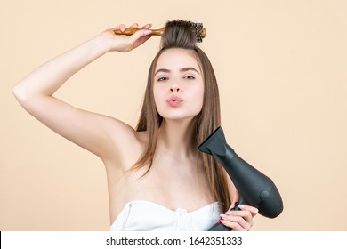 Blow dryer. Drying long brown hair with hair dryer and round brush. Hairdresser blow drying her hair. Beautiful girl using a hair dryer - Powered by Shutterstock