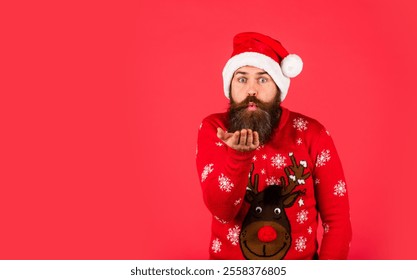 blow kiss. handsome man at Christmas. brutal bearded male red background. party man in Christmas sweater. happy caucasian guy await new year present. lets have fun. Santa Claus hipster. copy space - Powered by Shutterstock