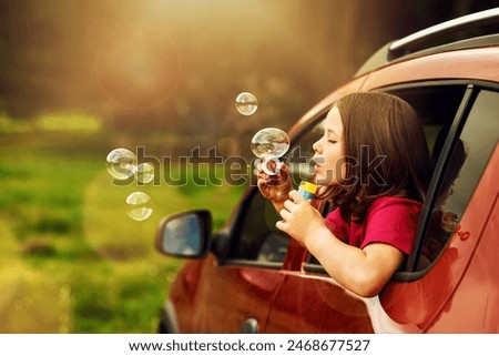 Blowing, bubbles and kid for fun by window in nature, outdoor or countryside in Australia. Child, girl and game in car for playing, freedom and childhood development of learning with soap toys