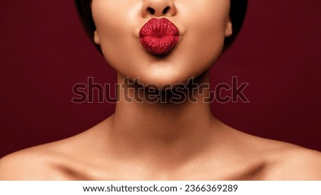 Blowing lips kiss. Young beautiful African american woman make pout lip glitter make up against red background