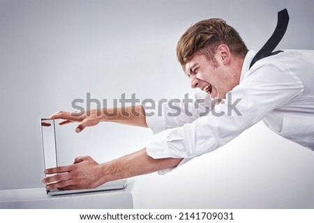 Blown away by the work load. Shot of a screaming man being blown away by the screen of his computer -CGI.