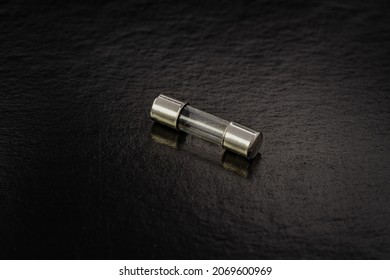 Blown cartridge electrical fuse on a black background