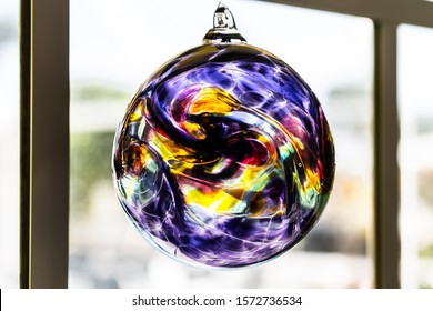 Blown Glass Sun Catcher Ball Hanging In A Window.