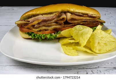 Blt Sub Sandwich With Potato Chips On A Plate