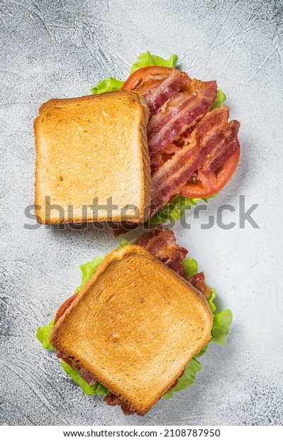 BLT toasted sandwich with bacon, tomato and\
lettuce. Gray background. Top\
view