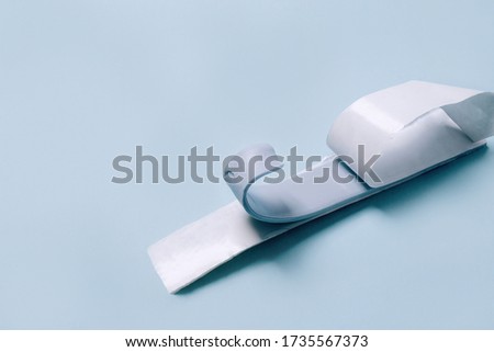 Blu Tack in a shape of thin flat strip on blue background.