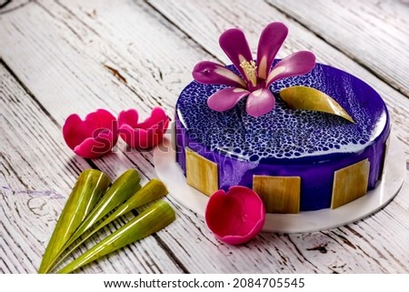bluberry cream cake with chocolate flower garnish and mirror glazing 