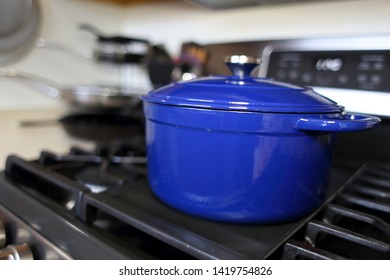 Blue 6 Quart Dutch Oven Resting On A Modern Natural Gas Stove.