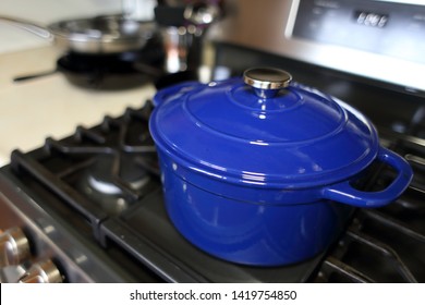 Blue 6 Quart Dutch Oven Resting On A Modern Natural Gas Stove.