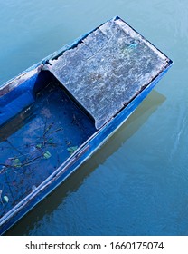 Blue Abandoned Row Boat, Vintage Blue Boat Sinking With Leaves Inside, Damaged And Left To Rot Rowing Boat By The Bridge