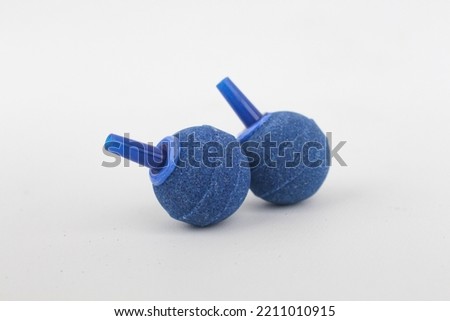 Blue Airstone, air stone or aquarium bubbler isolated in white. Made of limewood or porouse stone in ball shapes as a diffuser on air filtration system in a fish tank for healthy fish