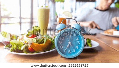 Blue alarm clock with IF (Intermittent Fasting) 16 and 8 diet rule and weight loss concept.-Diet plan concept
