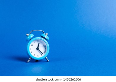 A blue alarm clock on a blue background. Limited offer and over time. Planning and discipline. waiting for a meeting. Punctuality. business planning. Life duration and health, increase your age. - Shutterstock ID 1458261806