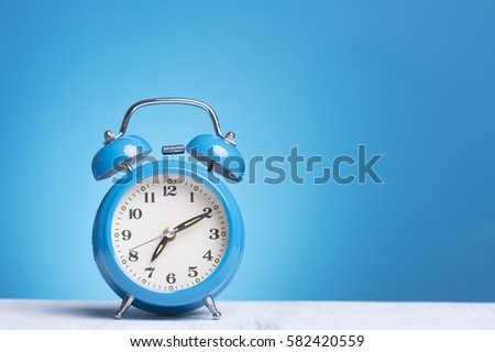 blue alarm clock on table