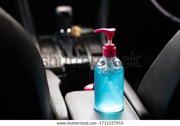 Blue alcohol gel bottle placed in the car. For\
washing hands Anti-virus and anti-bacteria and anti-virus Covid-19.\
copy space.