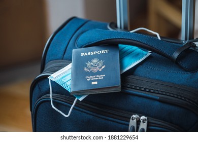 A Blue American Passport With A Blue Medical Mask On Top Of A Blue Suitcase