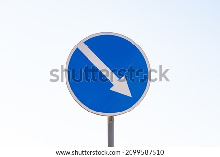 Blue arrow sign showing the way. Indicator sign. Finding the way. Road sign indicating the direction.