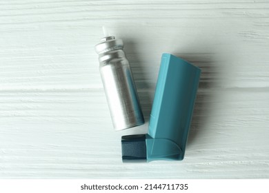 Blue Asthma Inhaler On White Wooden Table