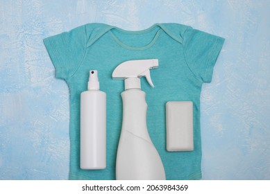 Blue Baby Bodysuit And Different Types Of Stain Removers. Dirty Clothes. Stubborn Stains. Clean Linen. Soap, Spray Bottle. Stains On Colored Clothing. Loss Of Color.Flat Lay, Mockup