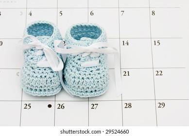 Blue Baby Booties On A Calendar Background, Baby Due Date