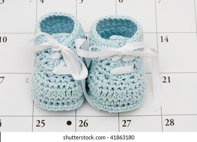 Blue Baby Booties On A Calendar Background, Baby Due Date