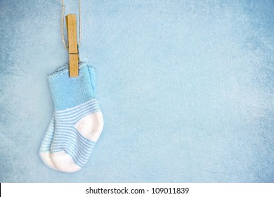 Blue baby socks on a textured rustic background with copy space