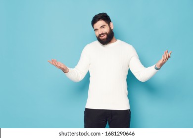 Blue background man in a light sweater gesticulating with his hands