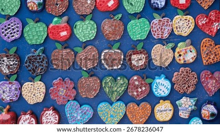 A blue background with many different colored apples on it. The apples are all different shapes and sizes. Mexico, zacatlan de las manzanas, puebla, day of the dead mexican tradition