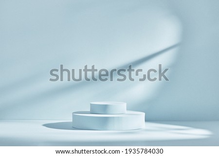 Blue background for product presentation with shadows and light. Empty round podiums. Mockup.