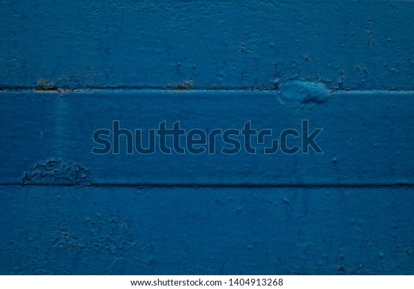 Blue background\
texture. Metal painted surface consisting of three equal horizontal\
parts. Two horizontal lines of material joining divide the image\
into three rectangular\
parts.