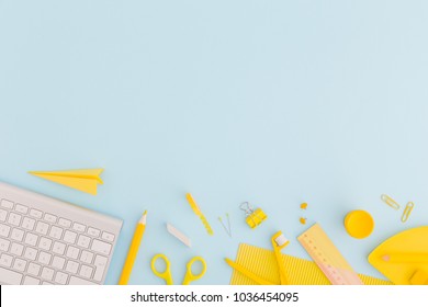 Blue Background And Yellow School Supplies. Flat Lay.