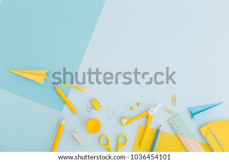 Blue background and yellow school supplies. Back to school. Flat lay.