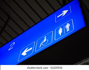 Blue Backlit Toilet Sign In The Airport