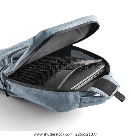 Blue backpack with a laptop inside the open main compartment. Rucksack for school or college or everyday use.