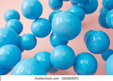 blue balloons, blue bubbles on pink background. Modern punchy pastel colors. Close up shot with shiny reflection