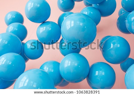 blue balloons, blue bubbles on pink background. Modern punchy pastel colors. Close up shot with shiny reflection