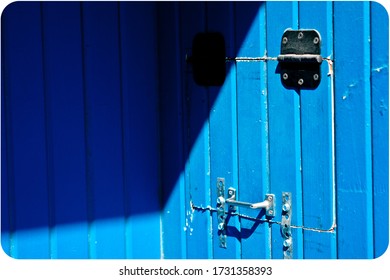 A Blue Barn Door In The Shadows