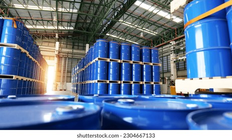 Los tambores químicos de barril azul de 200 litros están apilados en paletas de madera dentro del almacén a la espera de ser entregados. Concepto de industria química, industria petrolera y tecnología de transporte