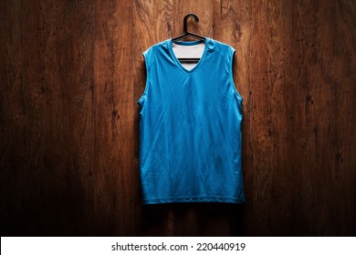 Blue Basketball Jersey Hanging On A Wooden Wall On A Hanger