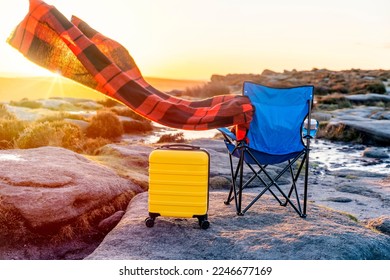 Blue beach chair, yellow  Suitcase, orange scarf in  the national park Peak District at sunrise. British cold winter. Local tourism concept. - Shutterstock ID 2246677169