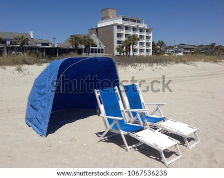 Blue beach chairs and sun / wind tent waiting for you.