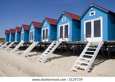 Blue beachhouses on a row on the beach