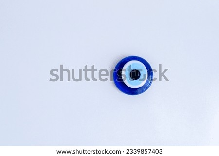 Blue bead worn against the evil eye with white background. Blue bead concept. Evil eye bead concept background. Copy space area. Selective focus.