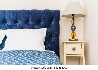 Blue Bed With Soft Headboard And Bedside Console With Lamp